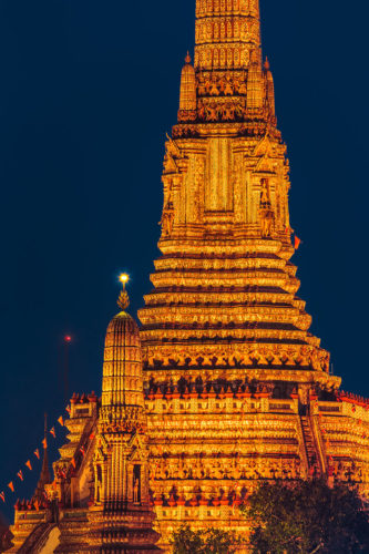 Night View of the Buddhist Temple of Dawn (Wat Arun) in Bangkok, Thailand, Southeast Asia. Taken from the other side of the Chao Phraya river with a telezoom lens.