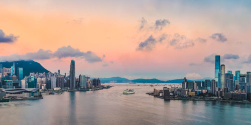 Panorama of Hong Kong at sunrise, with  Hong Kong Island on the left and Kowloon on the right